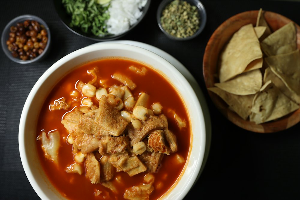 Stock photo of a bowl of red Mexican soup with tortilla chips